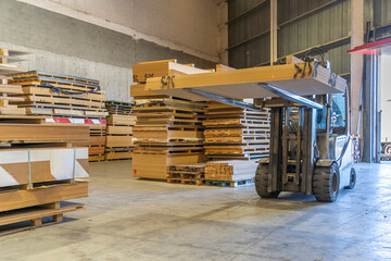 Forklift transporting wooden boards in a warehouse, highlighting logistics and woodworking industry processes