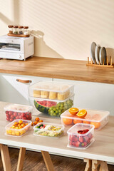 Fresh Produce Stored in Clear Plastic Containers on Kitchen Counter, Healthy food in plastic containers on table in kitchen. Food delivery
