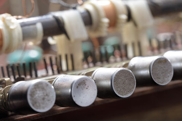 Macro shot of old vacuum tubes and electrical parts from vintage electronics, showcasing aged metal surfaces and analog technology.
