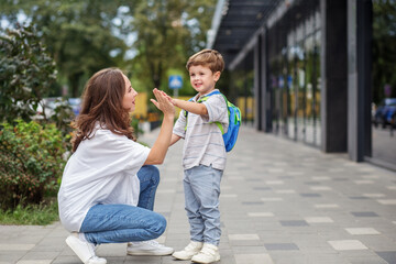 Mother giving son high five before school. Back to school