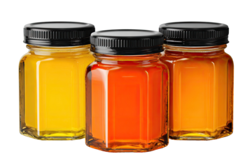 Three small, clear glass jars filled with honey of different colors.  Each jar has a black lid.  They are arranged in a slightly overlapping cluster