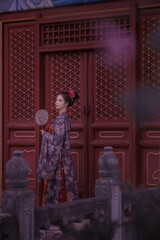 Traditional attire with elegant pose and fan Chinese word means beauty.