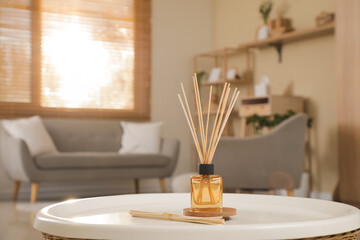 Aroma diffuser with reed sticks on table in room. Closeup