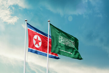 North Korea Saudi Arabia friendship flags are waving in the sky. Two country flag for agreement or deal. Korea KSA national flag for commitment.