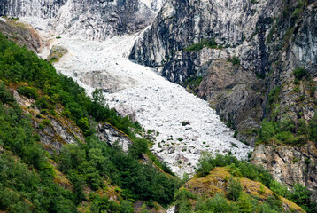 Majestic glacier flow amidst verdant mountain landscape