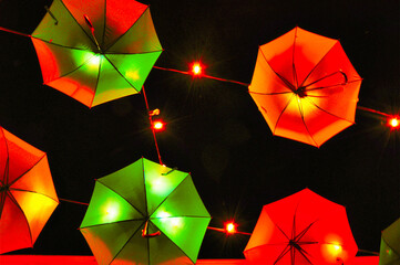 Wiszące kolorowe parasole - podświetlone na ulicy miasta. © Pol Badger