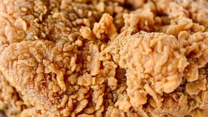 Close-up shot of a crispy, golden-brown piece of fried chicken, showcasing its textured surface and inviting appearance.