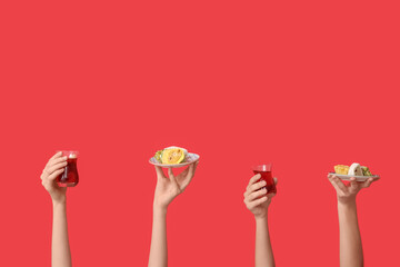 Female hands with Turkish tea and sweets on red background