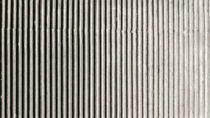 Obraz premium Grooved concrete surface creating rhythmic lines and shadows, textured wall finish
