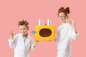 Funny inventors with burnt faces and device showing OK on pink background