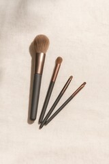 Realistic Makeup Brush Set on Linen Background with Soft Light