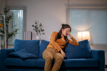 Naklejka premium Young woman feeling sad and depressed on sofa at home