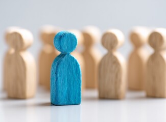 Blue Human Figure Among Wooden Mannequins on White Background - Individuality Concept with Bokeh Effect