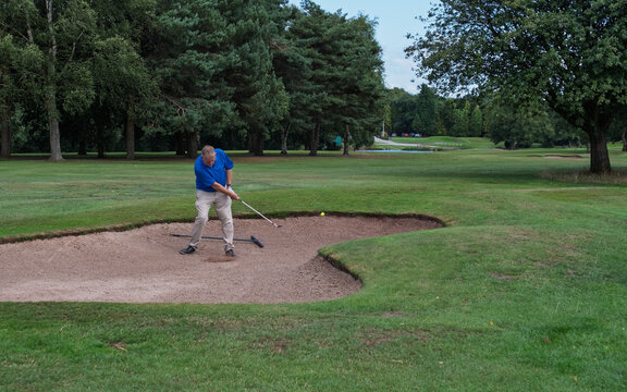 middle aged man playing bunker shot