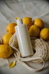 White bottle with lemons and mesh bag citrus