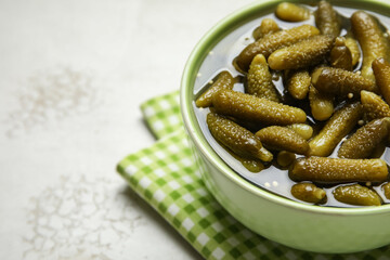 Bowl with tasty pickled cucumbers on grunge background