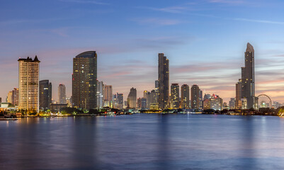 Obraz premium The Bangkok skyline at dawn, captured from Rama III Bridge. The city awakens under soft morning light, with skyscrapers silhouetted against a pastel sky