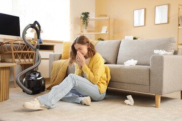 Young woman suffering from dust allergy while cleaning flat