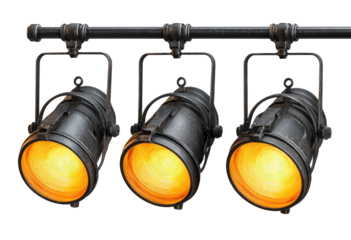 Three vintage spotlights mounted on a dark metal bar, emitting warm orange light