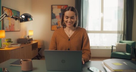 Young Caucasian Female Opening Up a Laptop and Starting to Work at Home. Woman Sitting Behind a Table in Living Room, Using Computer. Dynamic Close Up Portrait Made with a Robotic Camera Arm - Powered by Adobe