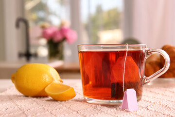 Cup of hot aromatic tea and lemon on table at home