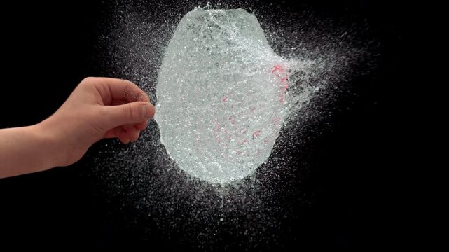 Slow Motion Of Needle Piercing Water Balloon Causing Liquid Splash - Powered by Adobe