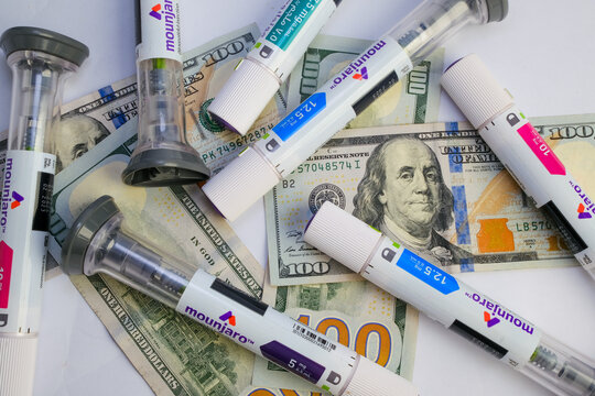 Basra, Iraq - August 5, 2025: Multiple Mounjaro Pens Scattered on US Hundred Dollar