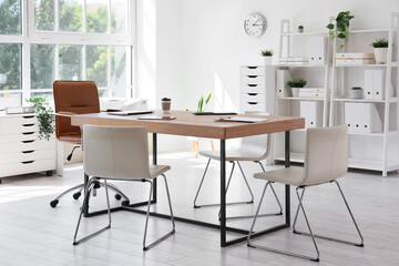 Interior of conference hall with table, shelf units and plants