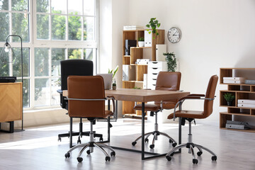 Interior of conference hall with table, shelf units and plants
