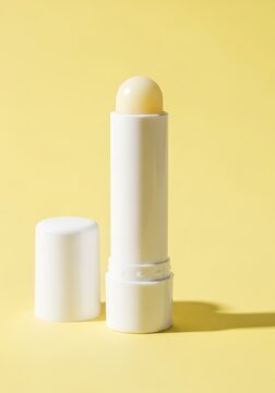 Blank white lip balm mockup on yellow background