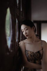 Contemplative young Asian woman in soft light.
