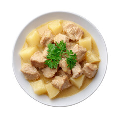 Delicious chicken stew with potatoes garnished with fresh parsley on a white plate.