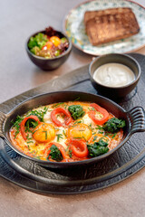A Deliciously Cooked Egg Dish with Fresh Vegetables, Served Alongside Toast and Creamy Sauce for an Inviting Breakfast Experience