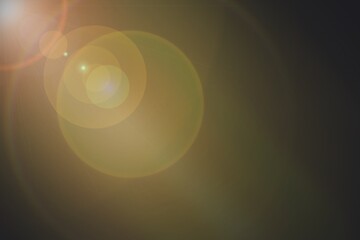 Abstract Golden Lens Flare Light Effect on Dark Background
Bright Sunlight Glow with Circular Bokeh Pattern
Soft Golden Light Burst with Lens Reflection on Black Backdrop