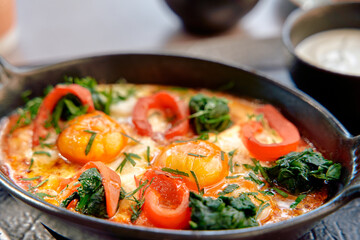 A Deliciously Crafted Dish Featuring Sizzling Eggs Surrounded by Fresh Vegetables and Vibrant Spices, Perfectly Cooked in a Skillet for Maximum Flavor