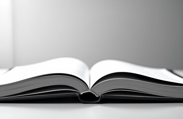 Fototapeta premium Open book with blank pages lying open on a white surface in a minimalistic setting