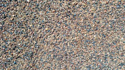 Gravel texture with multicolored small stones and sand. Natural rocky surface with crushed pebbles. Outdoor material background