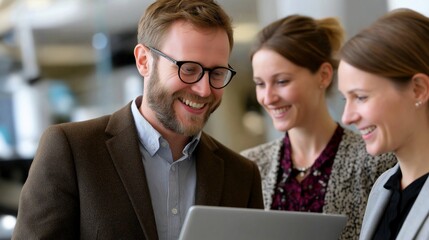 Fototapeta premium Happy business team looking at laptop together portrait image. Bearded man in glasses interacting with two smiling female colleagues photography. Project sharing concept photo-realistic