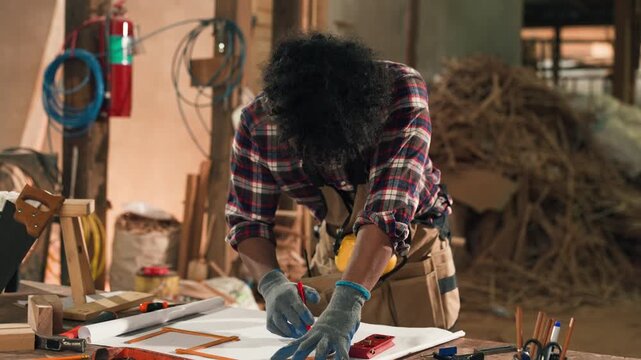 Young African American carpenter designing and building wooden chair at workbench in wood workshop, showcasing craftsmanship, creativity, and hands-on furniture making process with precision.
