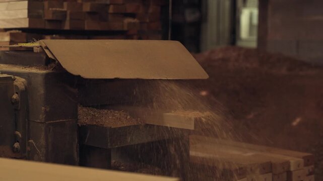 Close-up on Thickness Planer machine, wood worker working in factory, focus on the sawmill is cutting wood in wood factory, covered with dust from the sawdust in the timber factory.