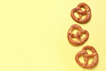 Tasty salted pretzels on yellow background