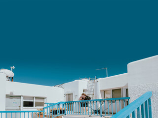 Obraz premium Modern white Mediterranean architecture with bright blue railings and deep sky