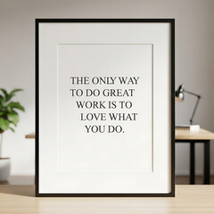 Framed motivational quote on a table, with a desk and plant blurred in the background.