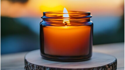 Beautifully Illuminated Amber Candle in Glass Container Reflecting Sunset Colors for Cozy Evenings