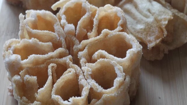 Detailed close up of a Flor Frita, a traditional Spanish sweet known as flor&oacute;n, resting on a wooden surface