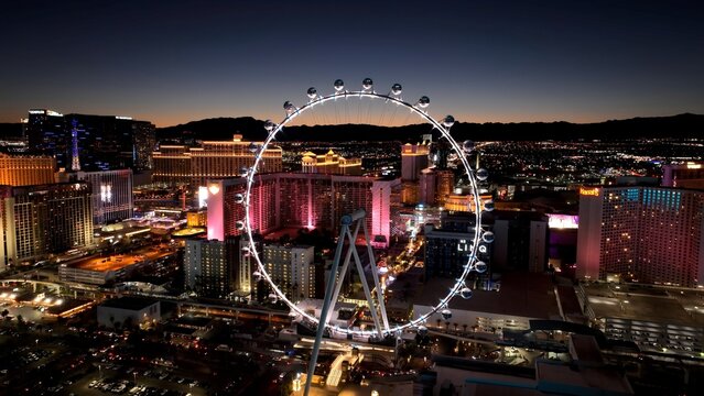Fototapeta Ferris Wheel In Las Vegas Nevada United States. Las Vegas Skyline Showing Modern Architecture And Festive Scene. Building Industry Skyline Birds View Vibrant. Sunset. Las Vegas Nevada.
