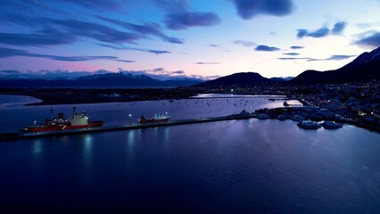 Sunset City In Ushuaia Tierra Del Fuego Argentina. Bustling Downtown Cityscape With Modern Buildings. Sunset Sunrise Mountain. Nature Sky High Angle View. Ushuaia Tierra del Fuego.