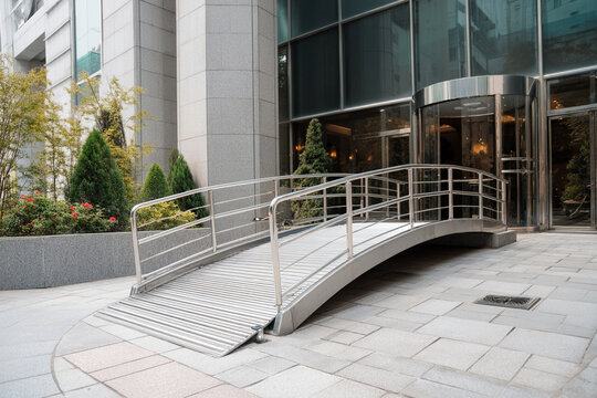 A generic wheelchair ramp gracefully curving into a modern, accessible building entrance, inviting universal access.