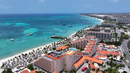 Naklejka premium Palm Beach In Oranjestad Caribbean Netherlands Aruba. Modern Glass Skyscraper Soars Above A Bustling City. Paradise Landscape Idyllic Amazing. Paradise Coast. Oranjestad Caribbean Netherlands.
