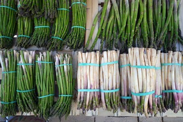 Bunches of white asparagus with purple tips and green asparagus at a French farmers market
